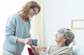 Młoda kobieta podająca herbatę starszej pani 