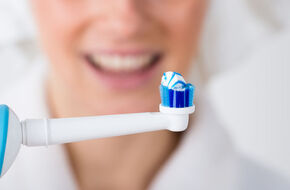 Kobieta używa szczoteczki sonicznej