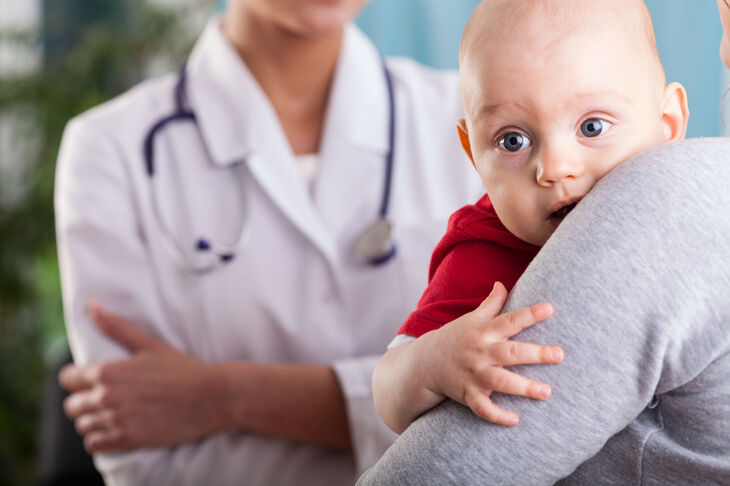Niemowlę u mamy na rękach podczas wizyty u lekarza