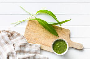Pesto z czosnku niedźwiedziego na drewnianej desce do krojenia