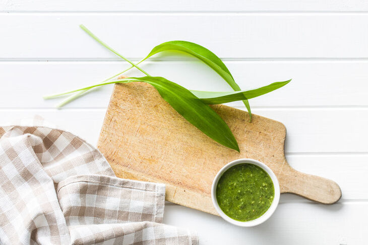 Pesto z czosnku niedźwiedziego na drewnianej desce do krojenia