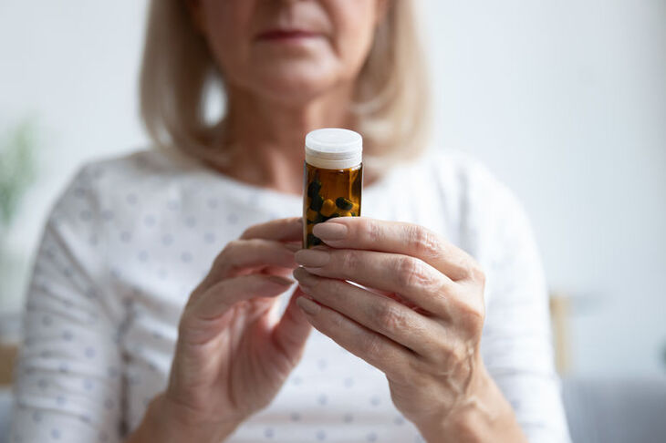 Kobieta łyka zioła na menopauzę