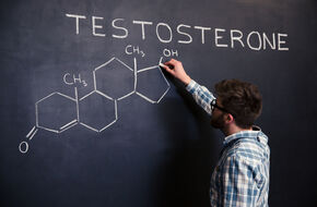 Mężczyzna pisze na tablica wzór chemiczny testosteronu 