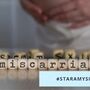 Słowo MISCARRIAGE składa się z drewnianych liter. Kobieta w ciąży w tle