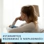 Zmartwiona kobieta siedzi na kanapie i patrzy w okno