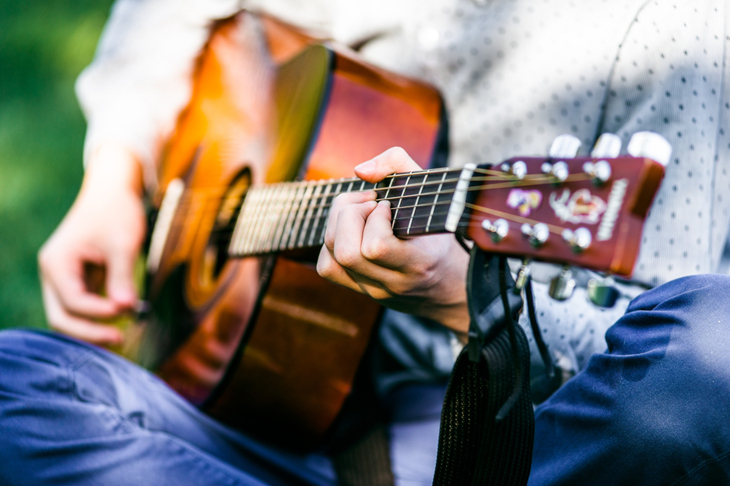 Mężczyzna gra na gitarze korzystając z muzykoterapii