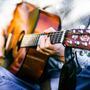 Mężczyzna gra na gitarze korzystając z muzykoterapii