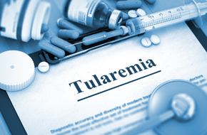 Napis tularemia na tablecie w otoczeniu leków