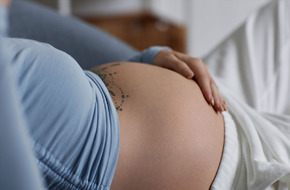 Kobieta prezentująca swój twardy brzuch w okresie ciąży