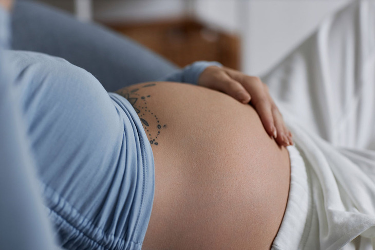 Kobieta prezentująca swój twardy brzuch w okresie ciąży