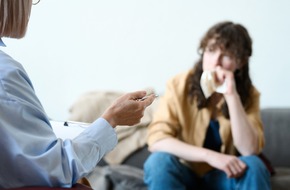 Kobieta trzyma chusteczkę w ręki i siedzi na kanapie u psychiatry zastanawiając się nad rekordową liczbą zwolnień lekarskich z powodu zaburzeń psychicznych