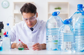 Zdjęcie przedstawia naukowca w laboratorium, analizującego próbki wody w kontekście badań nad mikroplastikiem w ludzkim mózgu.